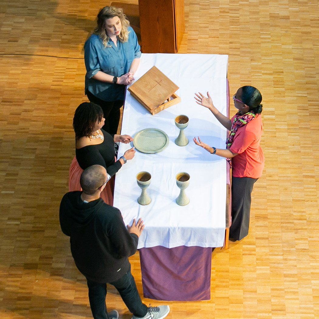 four people setting up communion altar