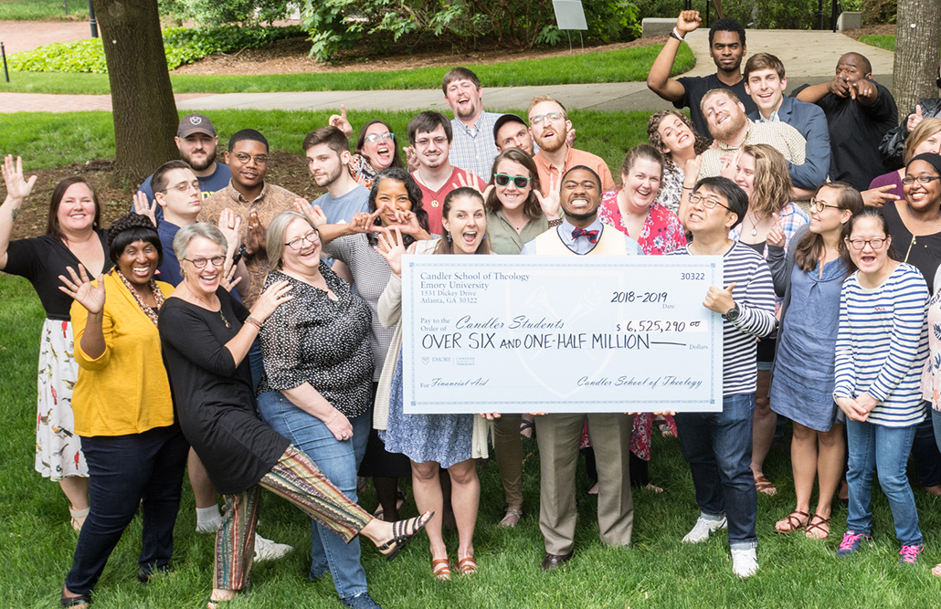 group of students hold oversized check showing scholarship money