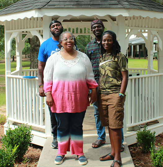 four people standing in front of a gazebo