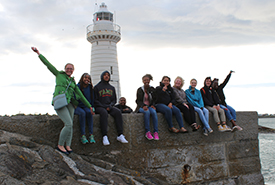 YTI students standing in front of a lighthouse in Northern Ireland