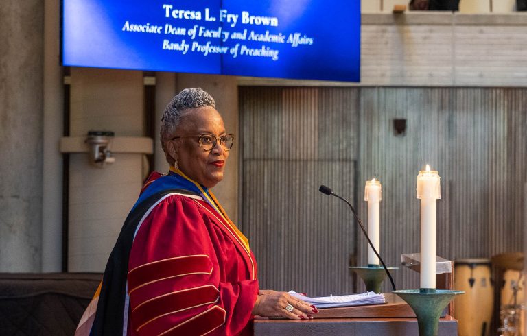 Teresa Fry Brown stands at Cannon Chapel lectern in academic regalia