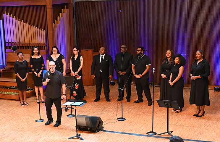 Choral singers dressed in black stand in Cannon Chapel