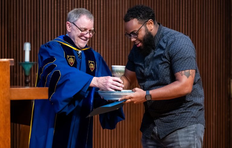 Ed Phillips hands a student honoree a chalice